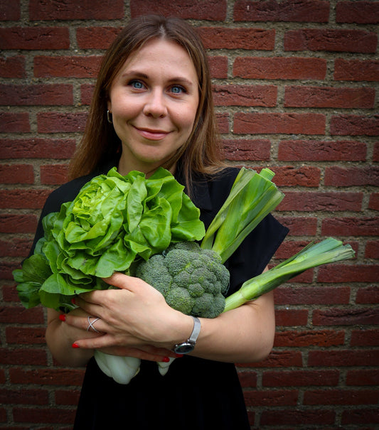 woman with green vegetables: broccoli, lettuce, leek