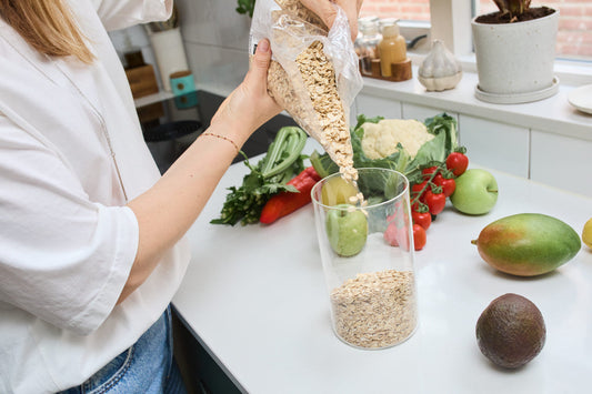 kitchen. girl pouring oatmeal into glass jar. healthy eating